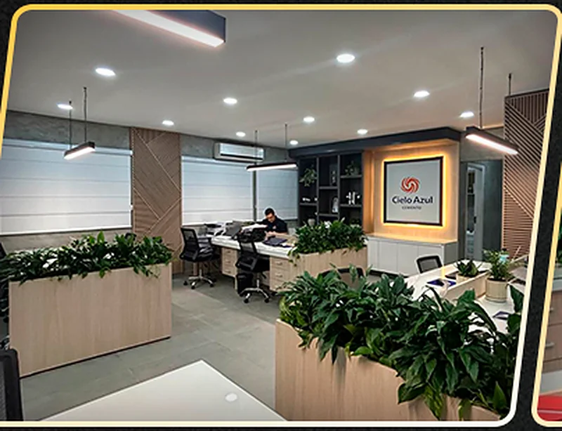 Oficina corporativa con puestos de trabajo, recepción iluminada y revestimiento de madera.