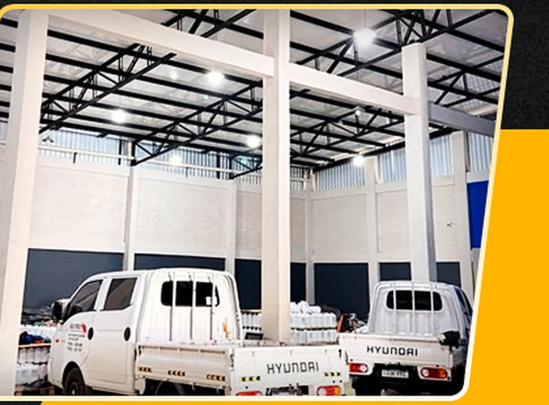 Interior de tinglado comercial con playa de vehículos y estructura metálica.