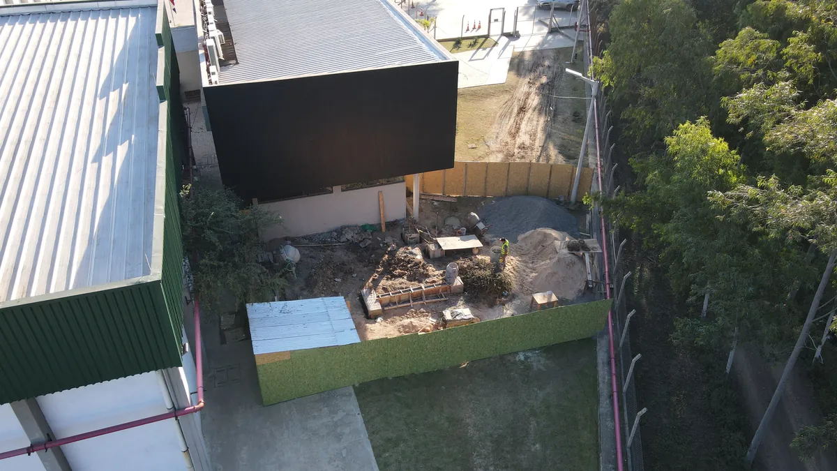 Obra industrial en ejecución vista desde el aire, con la nave del cliente en funcionamiento al lado.