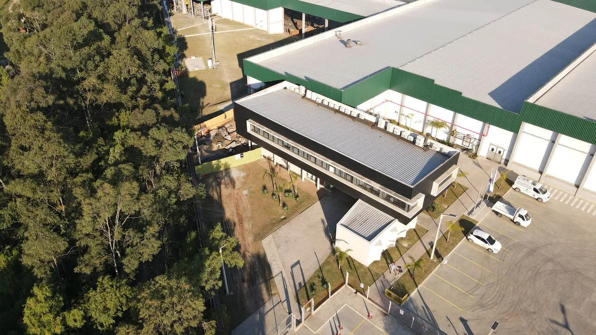 Vista aérea de una obra en ejecución de V3 Constructora, con el edificio de oficinas ya terminado junto a la nave industrial.